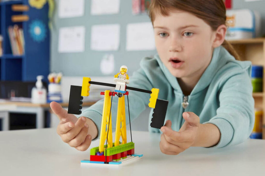 Mädchen spielt mit LEGO-Modell